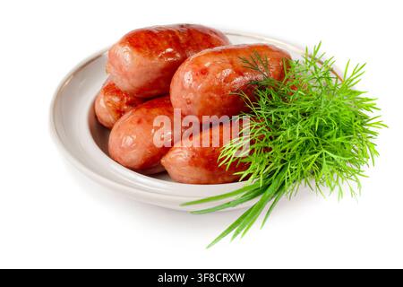 Fried sausages with greens in a plate. Sausages on a white background. Stock Photo