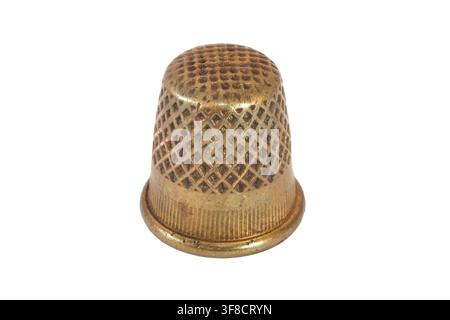 An antique copper thimble on a white background. Thimble for sewing close-up. Stock Photo