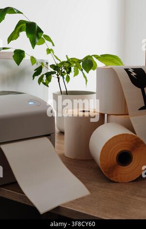 Label printer, paper rolls and fragile shipping labels for small business order fulfillment. Packaging automation streamlines ecommerce operations and Stock Photo