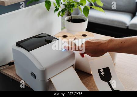 Label printer, paper rolls and fragile shipping labels for small business order fulfillment. Packaging automation streamlines ecommerce operations and Stock Photo