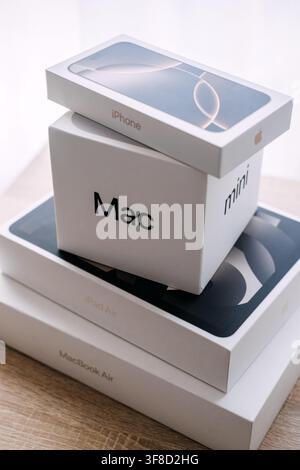 Stack of Apple product boxes on wooden table. Apple product unboxing, new apple devices boxes, unpacking apple tech purchase. Warsaw, Poland, 20 July Stock Photo
