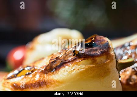 Extreme close-up shot of grilled yellow peppers featuring charred skin, tender cooked flesh, and a shallow depth of field highlighting the rich textur Stock Photo