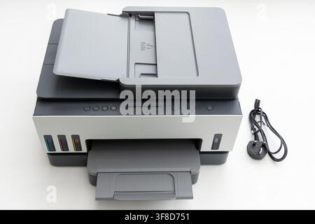A modern multifunction printer stands on a clean white surface Stock Photo