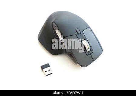 A modern wireless computer mouse sits next to its USB receiver Stock Photo