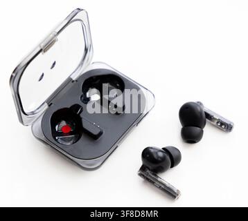 Wireless earbuds and an open charging case on white background Stock Photo