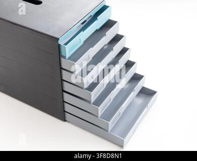 A modern plastic desk organizer with multiple open sliding drawers Stock Photo