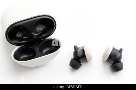 Wireless earbuds and their charging case on a white background Stock Photo