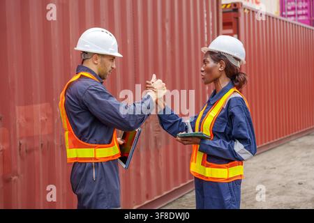 Two construction workers collaborating on a project at a shipping yard during a safety meeting. Ideal for construction, teamwork, engineering, and ind Stock Photo