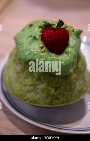 Matcha, green tea shaved ice with strawberry on top, served in a bowl Stock Photo