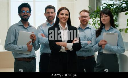 Happy multiethnic business team posing with crossed arms looking at camera indoor office smiling men women female leader confident colleagues Stock Photo