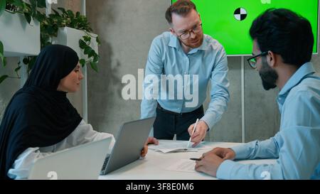 Multiethnic business team brainstorming indoor office boardroom discussing project corporate colleagues businessmen muslim hijab businesswoman talk Stock Photo