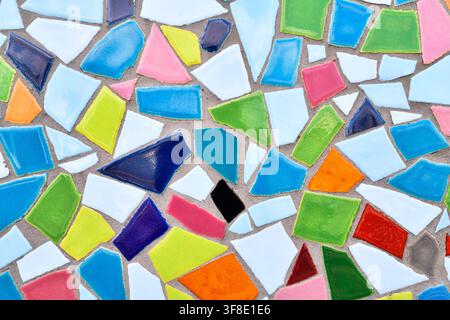 Close up of wall made of irregular colorful mosaic stones, uneven textured decorative surface with vibrant pattern Stock Photo