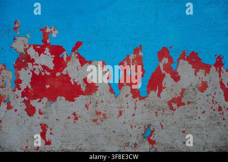 Peeling red and blue paint on old concrete wall grunge texture background. Stock Photo