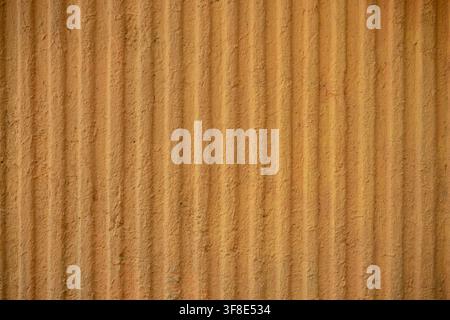 Yellow corrugated wall texture with vertical ridges and rough painted surface. Stock Photo