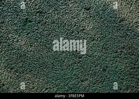 Green rubber crumb flooring texture of a playground or sports track surface. Stock Photo