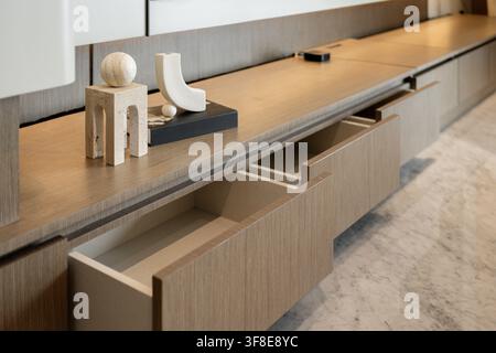 Modern wooden media console with open drawers and abstract geometric decorations. Stock Photo