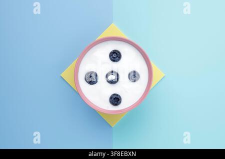 Natural Yoghurt with fresh blueberries on graphic colourful background Stock Photo