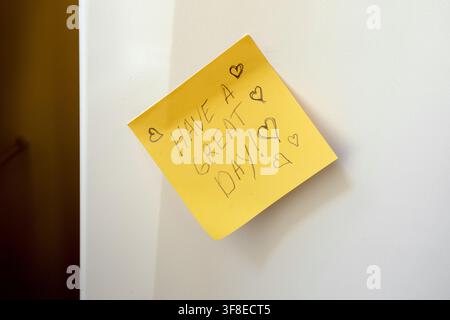 Yellow Sticky Note with Positive Message — “Have a Great Day!” on White Surface Stock Photo