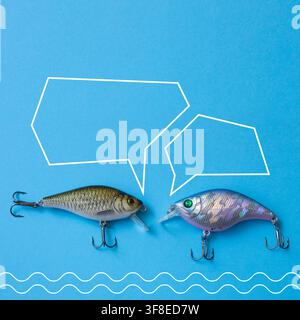 Two Colorful Fishing Lures with Speech Bubbles on Blue Background Stock Photo