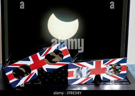 London, UK.  12 August 2026.  UK Weather – Certified solar eclipse 2026 glasses in a Union Jack style design in front of a laptop screen showing the 29 March 2025 partial solar eclipse, as seen from Primrose Hill, when the moon covered 30% of the sun.  It is reported that stocks of solar eclipse glasses in the UK have sold out ahead of tonight’s partial solar eclipse, visible from the capital, when 91% of the sun will be obscured.  Those disappointed are warned not look directly at the sun but to use pinhole cameras or other homemade devices instead.  Credit: Stephen Chung / Ģ����ý Live News Stock Photo