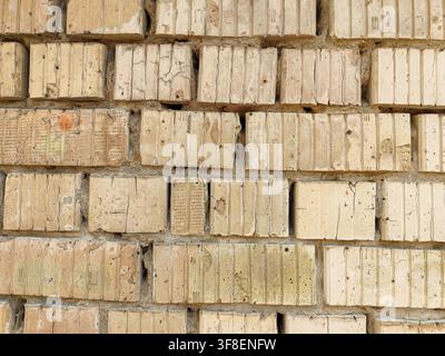 Background of Vintage Yellow Silicate Brick Wall with Grooves and Cracks. Stock Photo