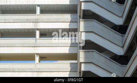 Concrete building exterior with fire escape staircase, minimalist architecture structure, geometric wall design with shadow, urban property developmen Stock Photo