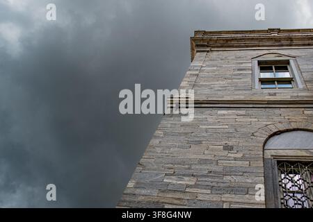 Historic Stone Building Under Dark Storm Clouds Stock Photo