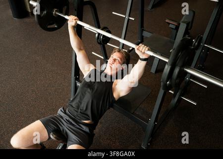 Man doing bench press with barbell in gym strength workout Stock Photo