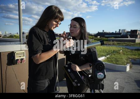Warsaw, Poland. 12th Aug, 2026. People use solar filter glasses to observe a partial solar eclipse at the Copernicus Science Centre in Warsaw, Poland on August 12, 2026. The Moon covered roughly 80 percent of the Sun's disc as seen from Warsaw at maximum eclipse, low on the western horizon near sunset; the eclipse was total only along a path crossing parts of Greenland, Iceland and Spain. (Photo by Jaap Arriens/Sipa USA) Credit: Sipa USA/Ģ����ý Live News Stock Photo