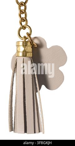 beige leather tassel keychain isolated white background, flower shape and gold metal chain hardware accessory side view in macro close-up Stock Photo