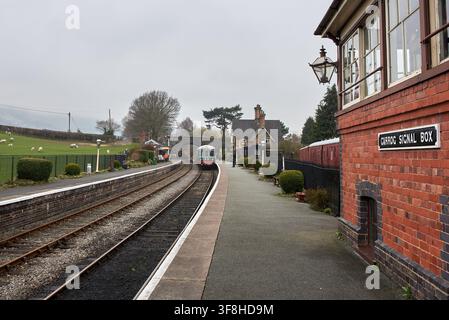 Vintage green DMU train arriving at Carrog station platform past the historic brick signal box on the Llangollen Railway in North Wales, UK. Stock Photo