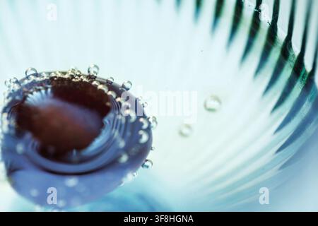 Cherry Floating in Champagne with Sparkling Bubbles Macro Background Stock Photo