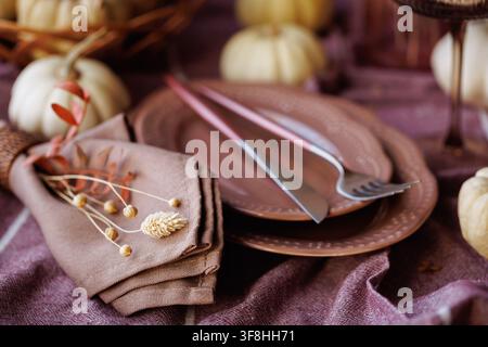 Elegant fall dining setup with rustic tableware and pumpkins Stock Photo