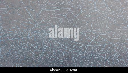 Close-up view of a textured grey surface featuring fine, light blue lines. These lines create a chaotic pattern resembling scratches, perfect for desi Stock Photo