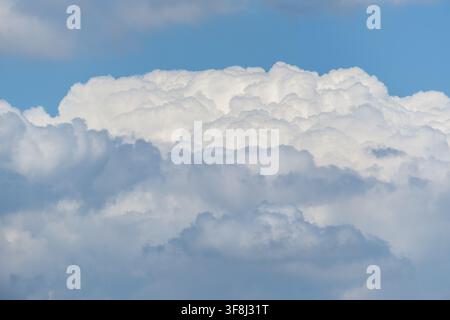 View of white cumulus clouds drifting across a clear blue sky in Jahanian, Pakistan. Stock Photo