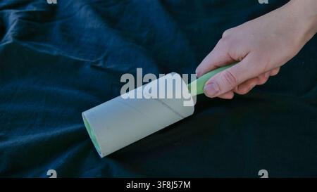 Lint Roller Held Over Textile Surface Stock Photo