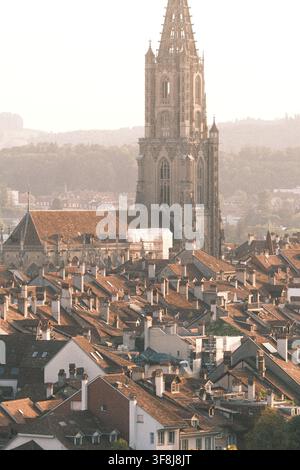 BERN, SWITZERLAND – AUGUST 12, 2026: Warm evening light falls over the rooftops of Bern Old Town with the Bern Minster cathedral rising above the hist Stock Photo