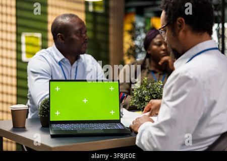 Isolated screen laptop used by engineering team in office automating repetitive tasks. Coworkers using coding program on chroma key notebook to speed up feature implementation Stock Photo