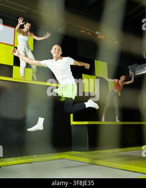 Cheerful young man jumping in modern indoor trampoline park Stock Photo