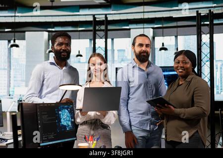 Portrait of happy software development team in office using AI to streamline app development. Smiling IT coworkers using devices to run debugging applications with machine learning technology Stock Photo