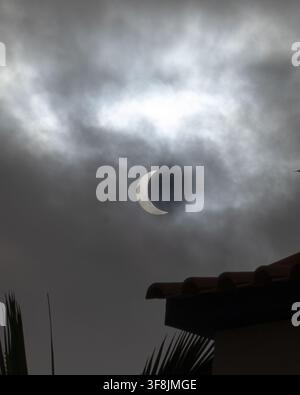 Close view of the crescent-shaped Sun partially covered by the Moon and visible through cloudy skies in Madeira, Portugal, on August 12, 2026. Partial Stock Photo