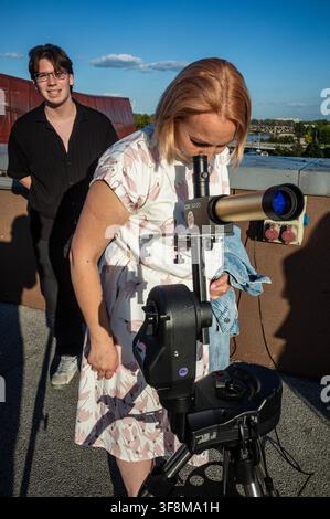 An observer seen viewing the sun through a telescope before the beginning of the solar eclipse. On the evening of the 12th August, Prime Minister of the Republic of Poland, Donald Tusk, joins scientific observers and members of the public at the Copernicus Science Centre in Warsaw to watch a partial solar eclipse. At its maximum, the Moon obscures about 82% of the Sun as viewed from the Polish capital. Warsaw's eclipse runs from approximately 19:14 until sunset at 20:06, reaching its maximum at 20:02. The roughly 82% figure refers to the Sun's covered area; the eclipse magnitude was about 0.85 Stock Photo