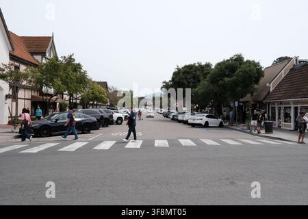 Pedestrians cross a street lined with Danish-style shops and buildings in Solvang, California, a popular tourist destination in the Santa Ynez Valley. Stock Photo