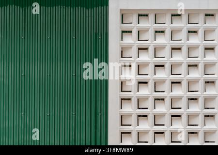 Green corrugated metal wall and white breeze block ventilation wall geometric texture background. Stock Photo