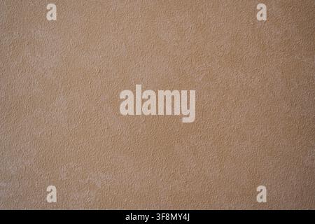 Light brown textured plaster wall surface background. Stock Photo