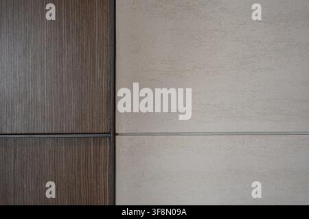 Textured beige plaster and dark wood paneling wall background with a vertical dividing line. Stock Photo