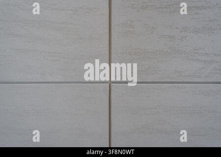 Light grey textured wall panel background featuring a symmetrical cross joint. Stock Photo