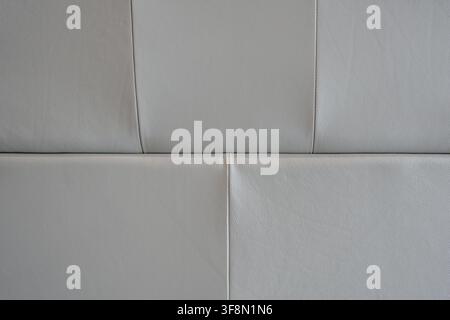 Light grey leather upholstery texture with stitching detail on padded panels. Stock Photo