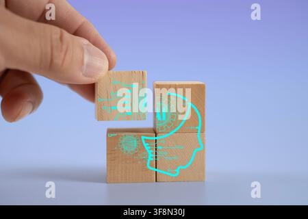Hand placing a wooden block to complete a digital AI head and circuit puzzle, representing artificial intelligence, machine learning, automation, inno Stock Photo