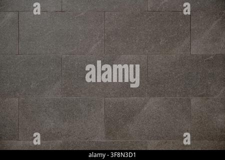 Stone wall tiles featuring a natural grey granite texture. Stock Photo